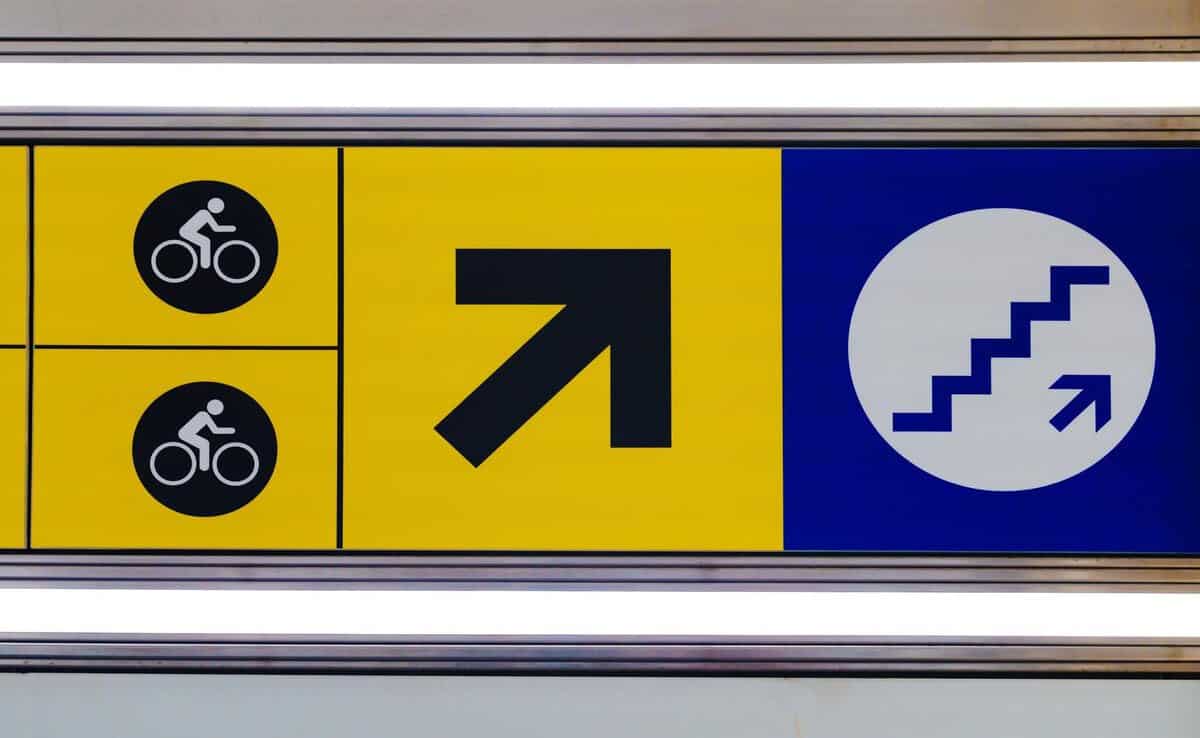 Brand-Husl- directional signage for cyclists and stairs, indicating routes for biking and stair access, with clear arrows and symbols for easy navigation.