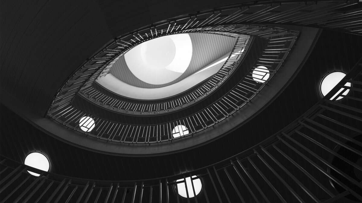 Aspirational spiral staircase with modern design and circular lighting, viewed from below, showcasing sleek architecture and creative interior design.